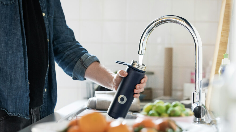 a man filling up water from a tap