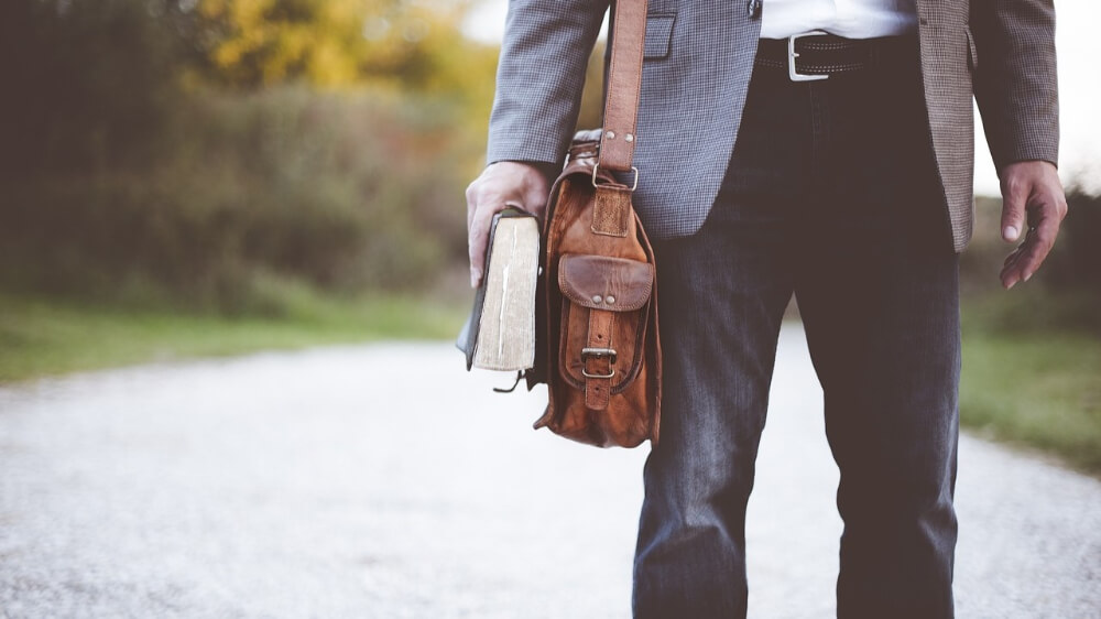 a man wearing jeans walks on the street