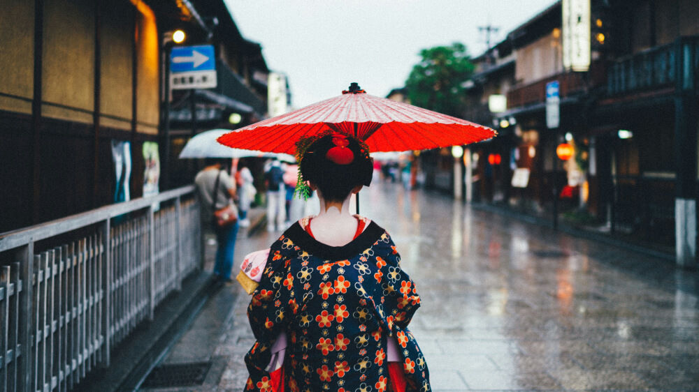 gaisha walk on the street with an umbrella at Gion in Kyoto