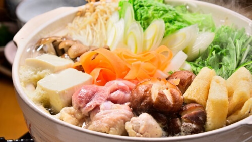 variety of vegetables and meats in a hot pot